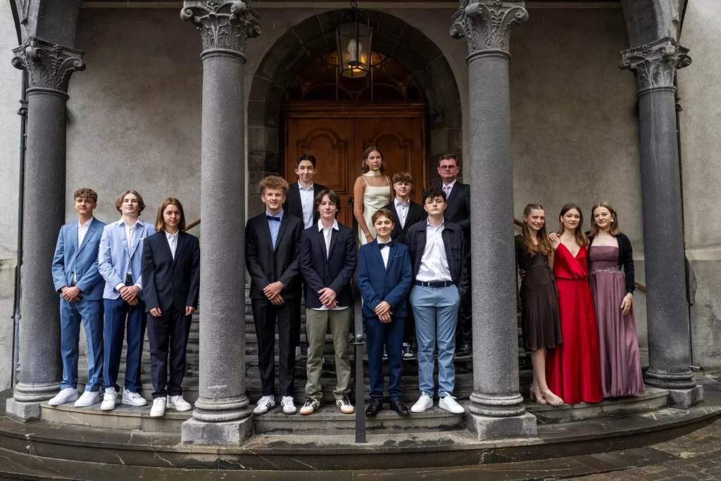 Gruppenbild Konfirmation 2024 vor der Martinskirche mit Pfarrer Robert Naefgen
