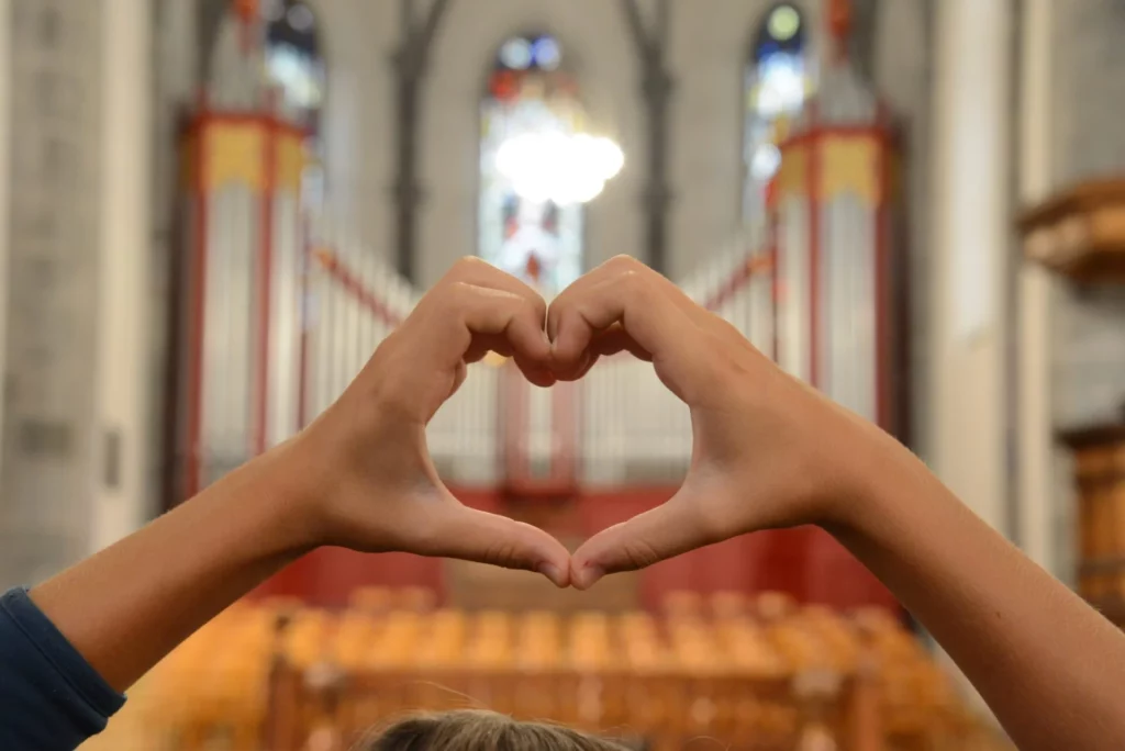 Kinderhände formen ein Herz vor der Orgel der Martinskirche