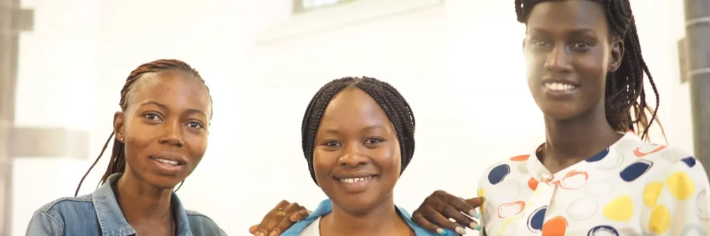 Drei Frauen blicken in dei Kamera